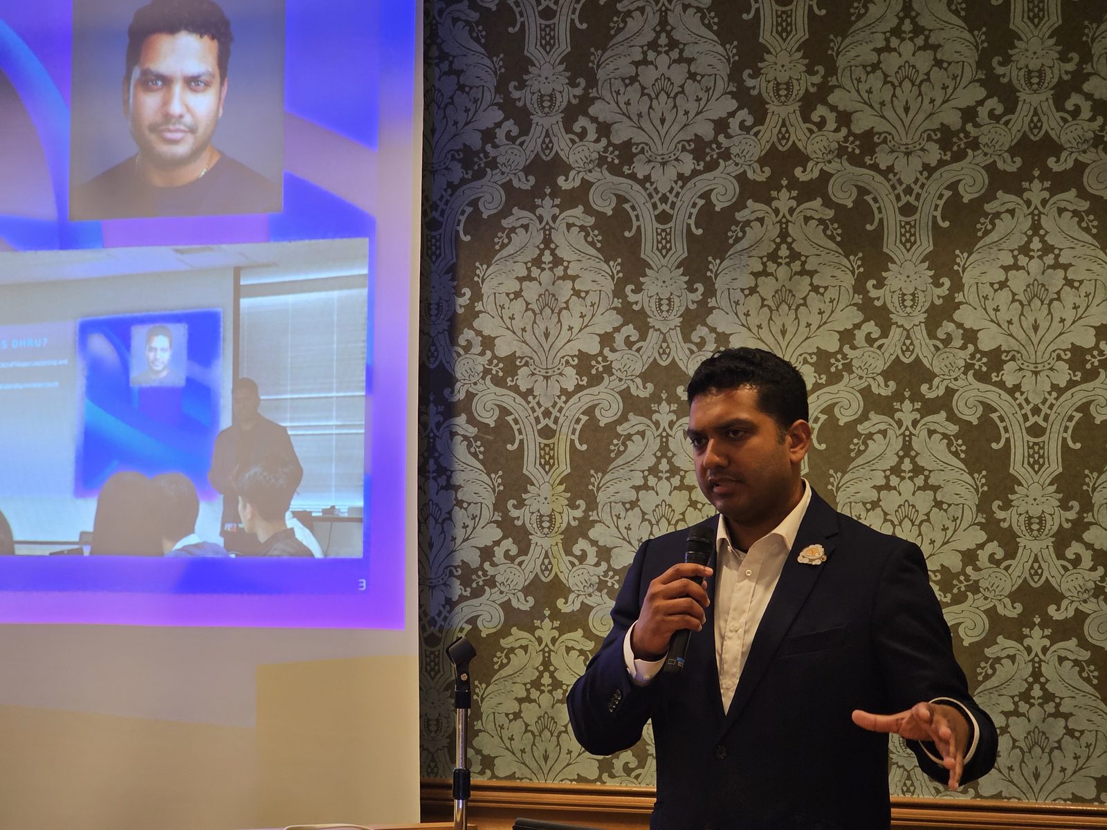 Dr. DhruBee speaking with a microphone